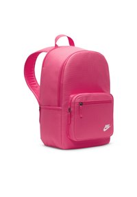 Ροζ σακίδιο Nike με λεία υφή, στρογγυλή μορφή, χερούλι στην κορυφή και μπροστινή τσέπη με φερμουάρ. Διαθέτει λευκό λογότυπο στο κάτω μέρος μπροστά.