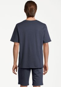 Mörkblå bomullströja med korta ärmar, rund halsringning och avslappnad passform, kombinerad med matchande shorts av samma material och färg.