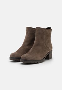 Botas de ante taupe hasta el tobillo con punteras redondeadas y tacones de bloque de 7 cm. Suelas texturizadas para un buen agarre; costuras cosidas alrededor de la parte superior para mayor durabilidad.