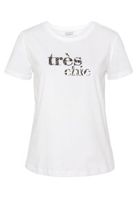 Weißes Baumwoll-T-Shirt mit dem Text "très chic" in einem Tarnmuster. Kurze Ärmel, runder Halsausschnitt und lockere Passform.