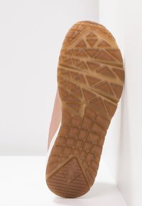 Sula i gummi med en texturerad yta av triangulära former, i en ljusbrun färg. Kanterna har en lätt vit accent.