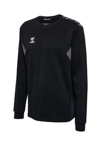 Czarna sportowa koszulka z długim rękawem, szarymi bocznymi panelami, dekoltem w serek i białym logo Hummel na piersi oraz wzorem zygzaków na prawym ramieniu.
