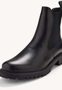 Bottes Chelsea en cuir noir avec panneaux latéraux en élastique, bout rond et semelle en caoutchouc texturée avec des profondes rainures pour une meilleure adhérence.