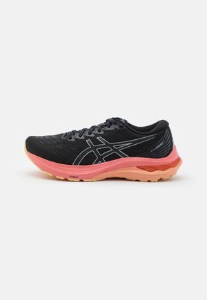 Schwarzer Laufschuh mit pinker und orangener Sohle, schwarzen Schnürsenkeln und weißem Logo an der Seite, auf weißem Hintergrund dargestellt.