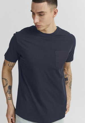 Marineblauw T-shirt van katoen met een ronde hals, korte mouwen en een contrasterende patch pocket op de linkerkant van de borst. Gladde textuur.