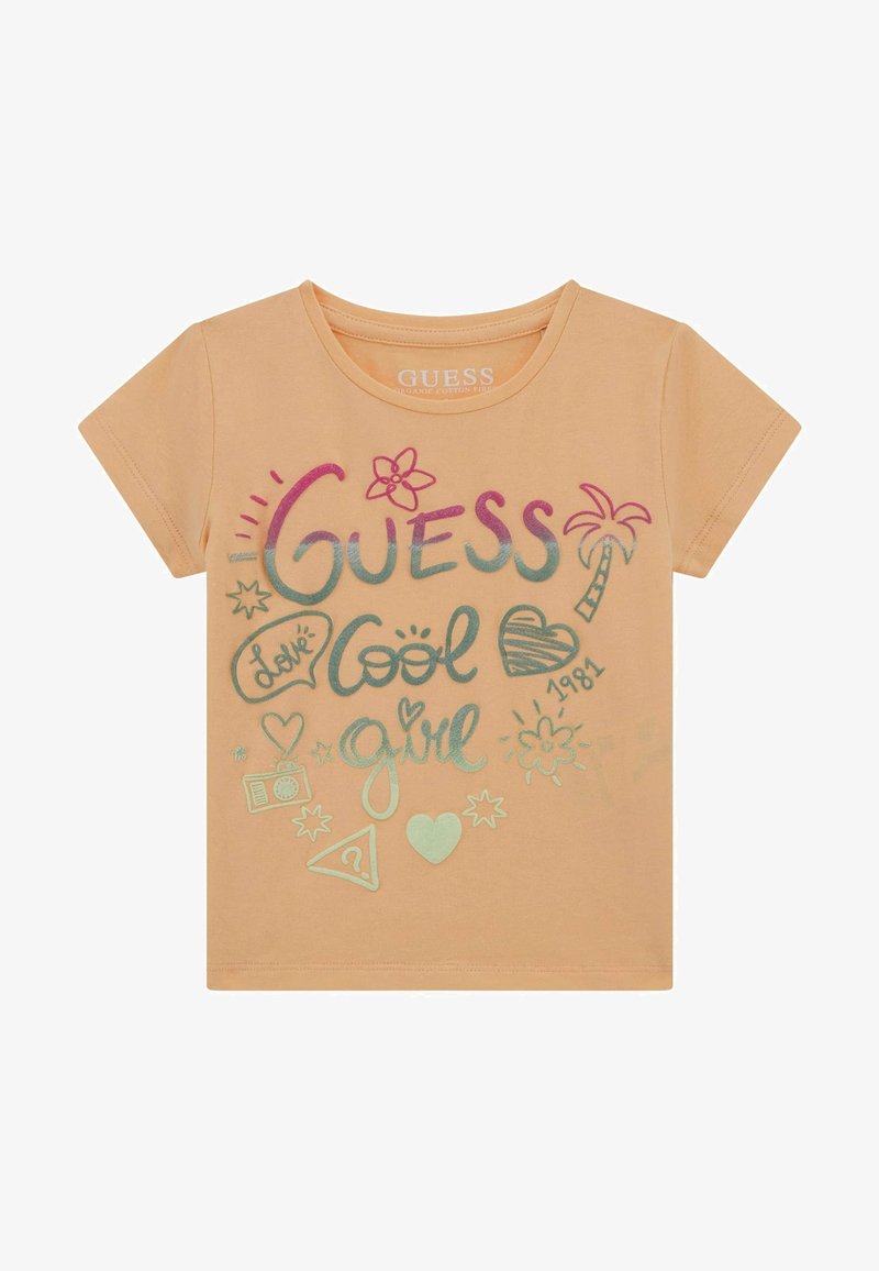 T-shirt di cotone color pesco con maniche corte, caratterizzata da grafiche multicolori tra cui "Guess", cuori, un fiore e una palma.