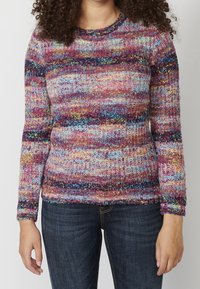 Pull en tricot multicolore avec un col rond, présentant des rayures horizontales en rose, violet, bleu et jaune, avec un tissu texturé.