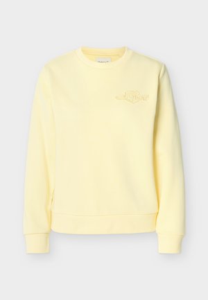 Light yellow crewneck sweatshirt with long sleeves and subtle chest logo embroidery on the left side.