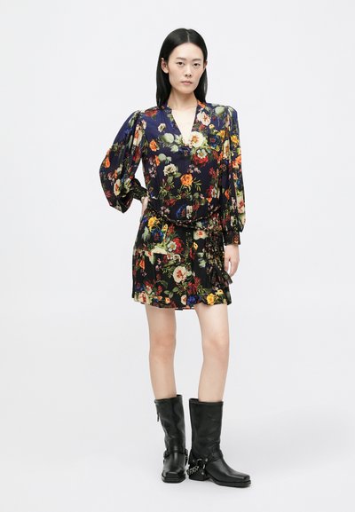 Virágmintás ruha sötét háttérrel, puffadt ujjak, V-kivágás és ráncolt szoknya jellemzi. Térdfelett érő fekete bőr csizmával párosítva.