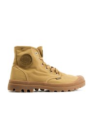 Bottines en toile beige avec semelle en caoutchouc et semelle à motifs, dotées d'œillets métalliques, d'un patch logo circulaire et d'un design à lacets.