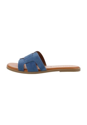 Flat slide sandal with tan sole and blue suede wide crisscross straps over the foot, shown from side on white background.