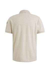 Polo léger beige avec une texture douce, manches courtes et col. Présente un petit accent noir sur la manche gauche.