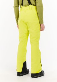 Gele skibroek met verstelbare bretels, waterdicht materiaal, zijritsen en zwarte accenten bij de boorden en zakken.