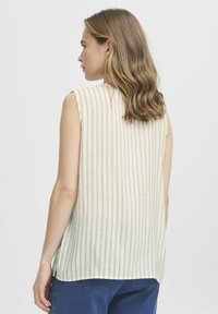 Ärmellös, ljusfärgad topp med vertikala ränder, som har en avslappnad passform och en liten sidoklyvning vid fållen. Slät textur.