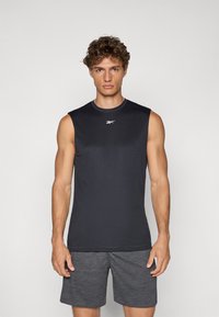 Sort ærmeløs træningsskjorte med rund hals og Reebok-logo på brystet, parret med grå teksturerede shorts. Tætsiddende design, letvægtsstof.
