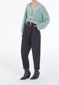 Mintgrön ribbad cardigan med v-ringning och knappar, i kombination med högmidjade svarta byxor och strukturerade svarta ankelboots.