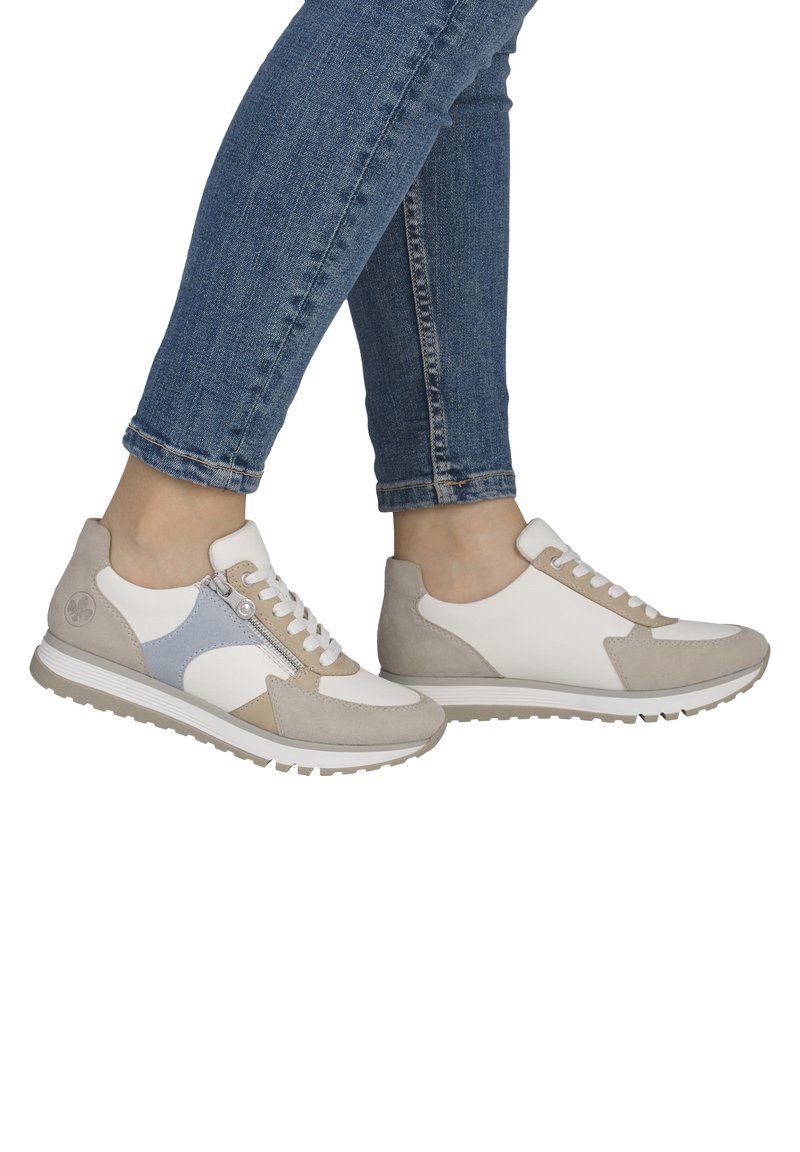 Baskets légères en blanc, beige et bleu doux, présentant un mélange lisse de cuir et de daim, un bout rond et une semelle texturée avec adhérence.