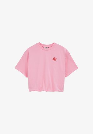 Rozā kokvilnas T-krekls ar īsām piedurknēm, apaļu kaklu un mazu sarkanu ziedu izšuvumu kreisajā pusē. Brīvs piegriezums ar nedaudz īsāku garumu.