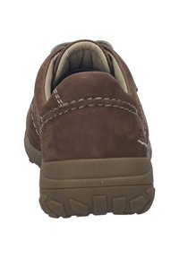 Chaussure de marche en daim marron avec des accents beige, une semelle en caoutchouc texturée et des détails cousus sur le dessus. L'arrière est arrondi et rembourré.