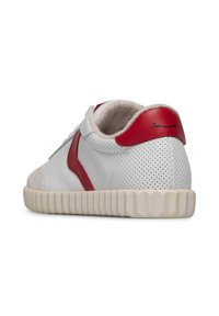 White perforated sneakers with red accents and a ridged beige sole. Features a soft interior lining and minimal branding on the heel.