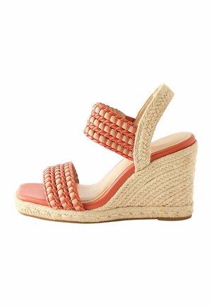 Wedge sandal with braided orange and beige straps, woven jute platform heel, and slingback strap on white background.
