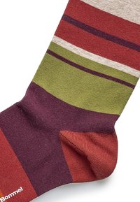 Multifarvet sok med vandrette striber i rød, grøn, beige og lila. Fremstillet af blødt, struktureret stof med ribbet design.