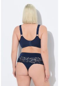 Conjunto de sujetador y braguita de color azul marino, con detalles de encaje en la cintura, tirantes ajustables y una textura suave.