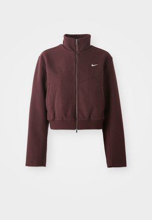 Geknipte bordeaux jacket met hoge kraag, ritssluiting, geribde zoom en lange mouwen. Bevat het witte Nike-logo op de linkerkant van de borst.