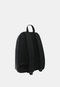 Sac à dos noir en matériau lisse avec un dos texturé. Comprend deux sangles réglables et une poignée supérieure pour un transport facile.