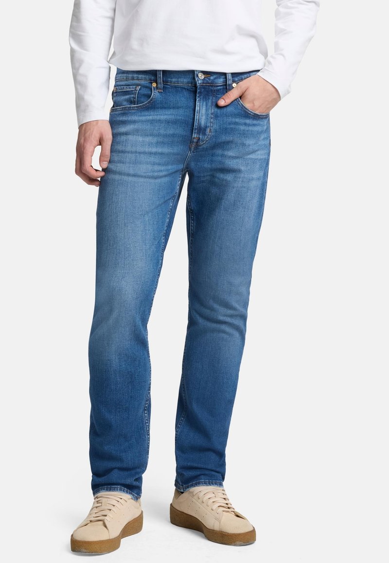 Blå denimjeans med rak passform, femficksdesign och subtila blekningar. Styla med beige sneakers som har texturerade sulor.