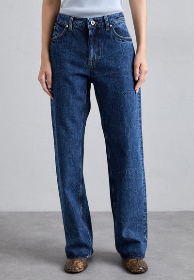 Blugi largi din denim, cu o suprafață texturată, design clasic cu cinci buzunare și închidere cu buton metalic la talie.