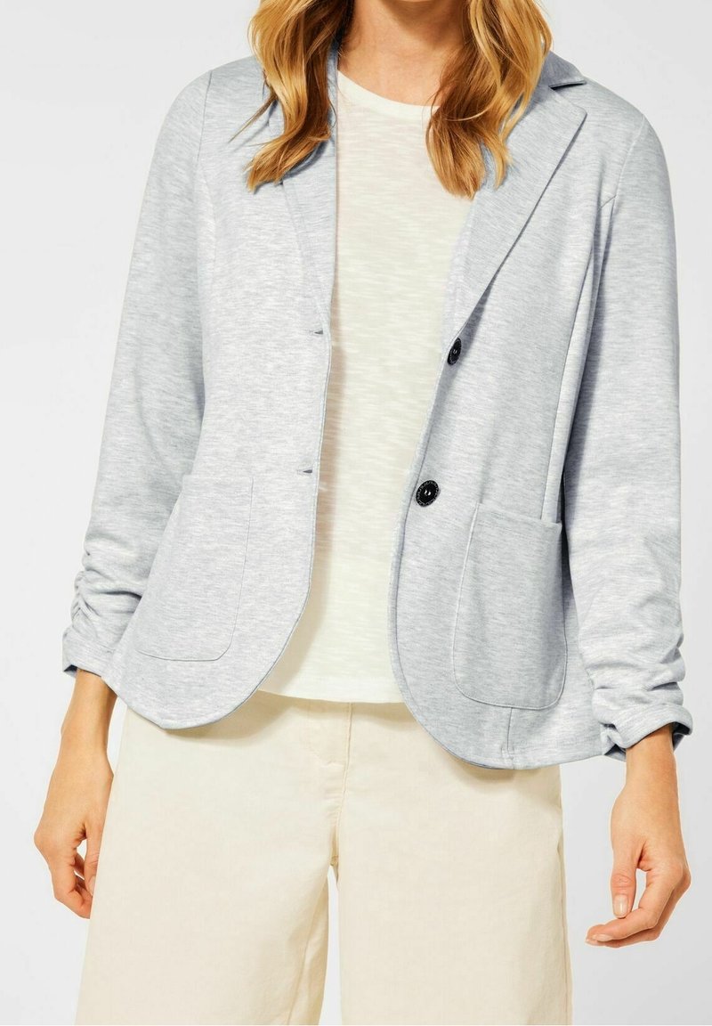 Blazer en jersey gris clair avec col, deux poches avant et deux boutons. Manches longues avec revers roulés et coupe décontractée.
