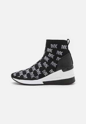 Baskets noires de style chaussette avec motif de texte "MK" blanc, semelle intermédiaire blanche épaisse, panneau de talon noir et languette sur fond uni.