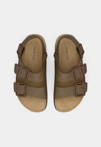 Pruunid nahast sandaalid kolmega reguleeritava rihmaga, pronksist pandlatega ja pehme sisetallaga. Tasane tald, mis on loodud mugavuseks ja stabiilsuseks.