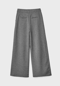 Pantalon gris à jambes larges avec passants pour ceinture et deux poches passepoilées au dos, vu de dos sur un fond uni.