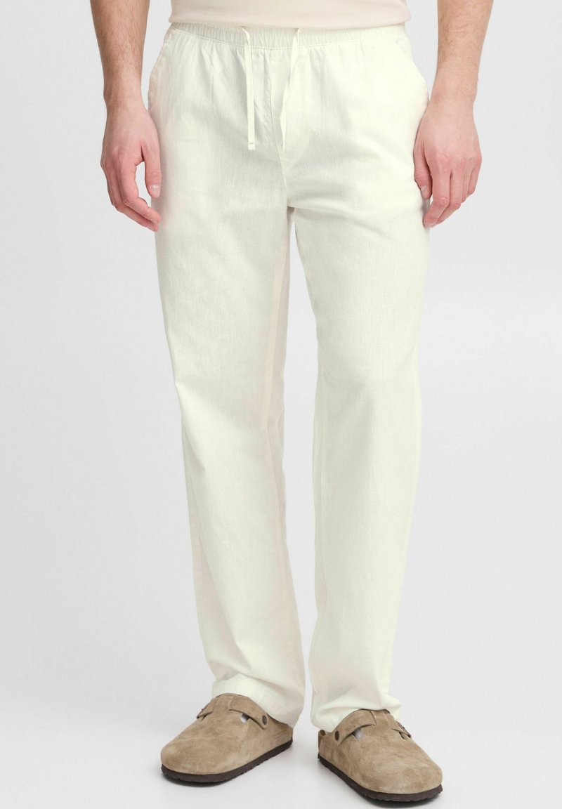 Lichtgekleurde linnen broek met een elastische tailleband en een koord, voorzien van zijzakken en een relaxte pasvorm. Zachte textuur en losse vorm.