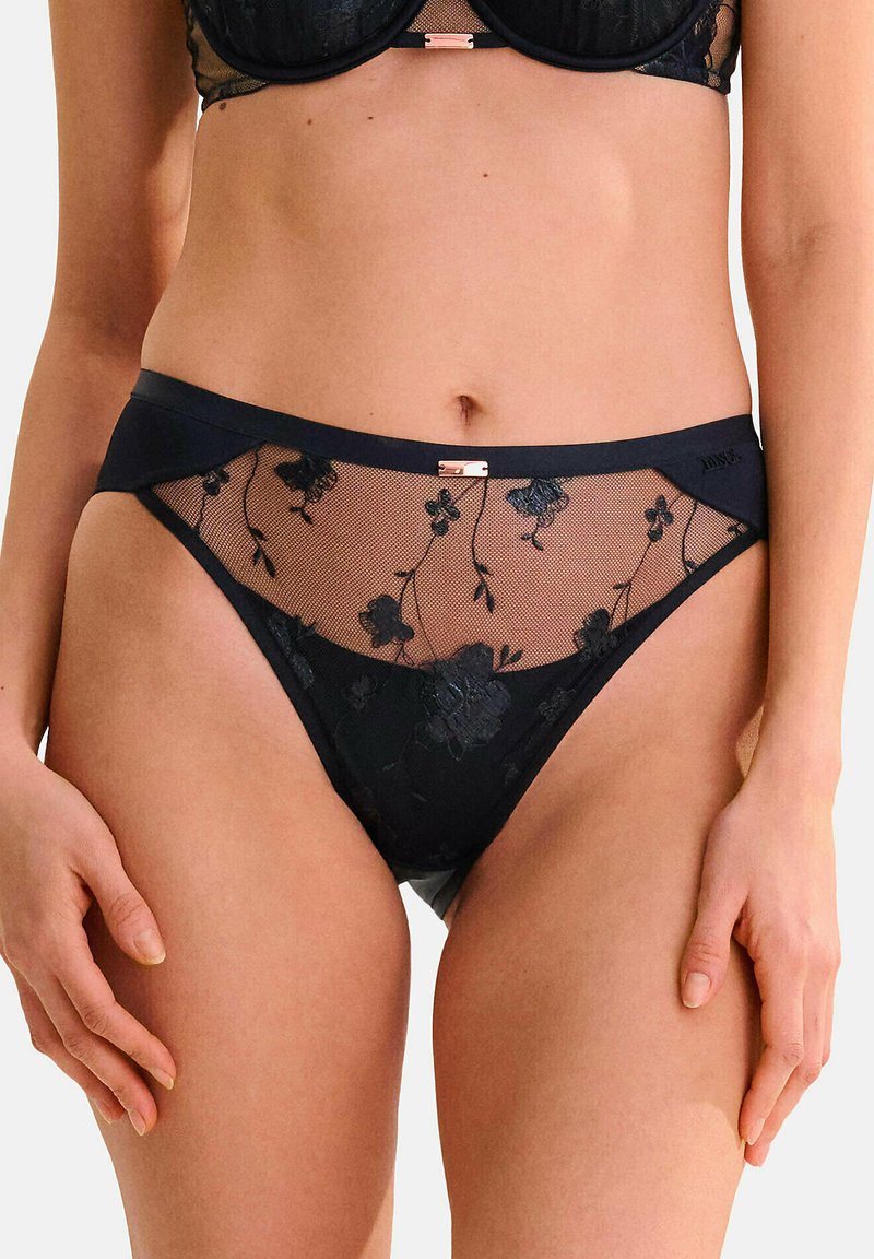 Culotte en dentelle noire avec des panneaux en tulle floral transparent, dotée d'une taille douce et de détails en métal rose doré.