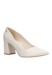 Pump bianco in pelle con tacco alto, punta affilata e tacco quadrato. Texture liscia con un sottile dettaglio del logo sul retro.