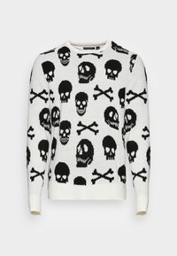 Vit tröja med ett upprepat mönster av svarta döskallar och korslagda ben, rund halsringning samt ribbade muddar och fåll. Tillverkad av stickat tyg.