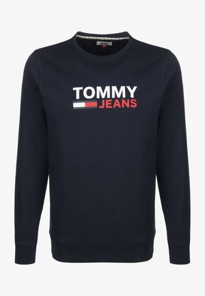 Tmavě modrá mikina z bavlněné směsi; má kulatý výstřih a žebrované manžety. Velké logo „TOMMY JEANS“ v bílé a červené barvě přes hrudník.