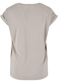 Ljusbeige t-shirt med avspänd passform, korta uppvikta ärmar, mjuk textur och rundad halsringning. Enkel och slät baksidesdesign.