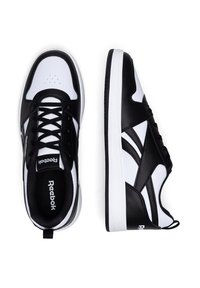 Adidași alb-negru din piele sintetică, cu vârful rotund, design cu șireturi, detalii perforate și branding Reebok pe limbă și călcâi.