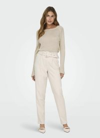 Beiger Langarmpullover mit rundem Ausschnitt; kombiniert mit hochtaillierten cremefarbigen Hosen, die über einen breiten Gürtel und einen geraden Beinverlauf verfügen.