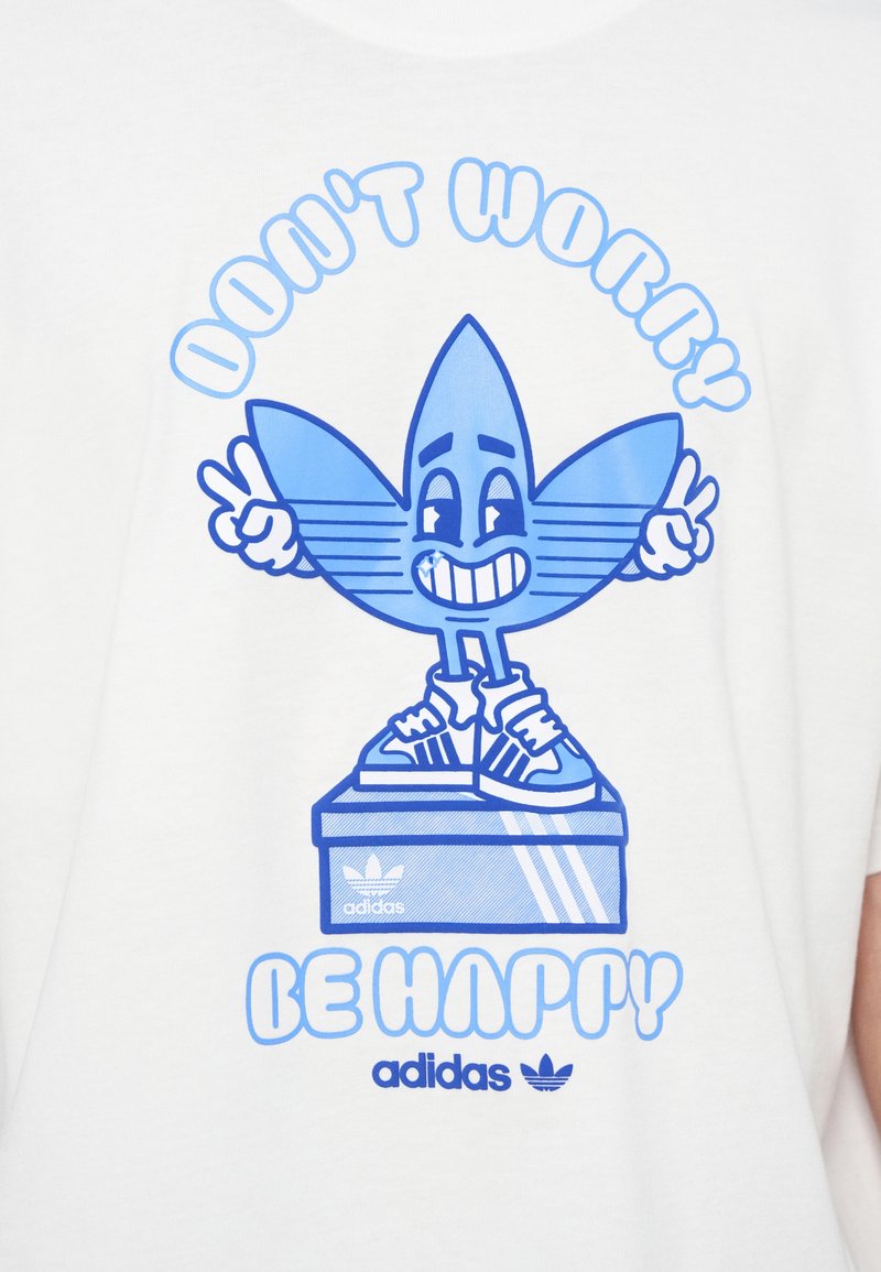 Weißes T-Shirt mit blauem grafischem Design, das eine lächelnde Figur auf einem Schuhkarton zeigt. Der Text lautet oben "DON'T WORRY" und unten "BE HAPPY".