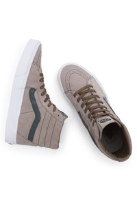 Sneakers alta in suede taupe con accenti grigi, fascia laterale testurizzata, lacci marroni e suole in gomma bianca. Design classico con dettagli di cucitura.
