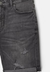 Shorts din denim gri cu un design uzat, având crăpături desfăcute și un tiv răsucit. Include buzunare standard și închidere cu button.