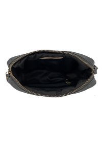 Interno di una borsa a mano in pelle nera con una texture liscia, chiusura con zip e un'unica tasca con slot per carte e un rivestimento scuro.