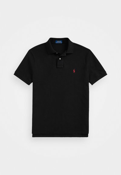Camiseta polo negra de algodón, con un polo clásico, mangas cortas y un pequeño logo rojo en el lado izquierdo del pecho.