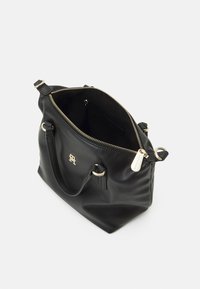 Schwarze Lederhandtasche mit goldenen Beschlägen, Reißverschluss und Logo-Akzent. Mittelgroß, mit weicher Textur, bietet zwei Griffe und Innentaschen.
