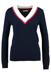 Suéter navy de manga larga, con escote en V que presenta acentos en blanco y rojo, textura suave, y puños y dobladillo acanalados.